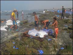 أطفال وشباب يجمعون مناديل ورقية لفظها البحر
